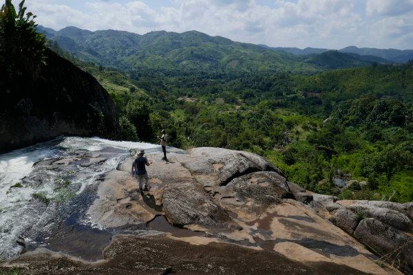 Blick vom Wasserfall (links) und Steilstufe in tropisch bewaldetes Gebiet.